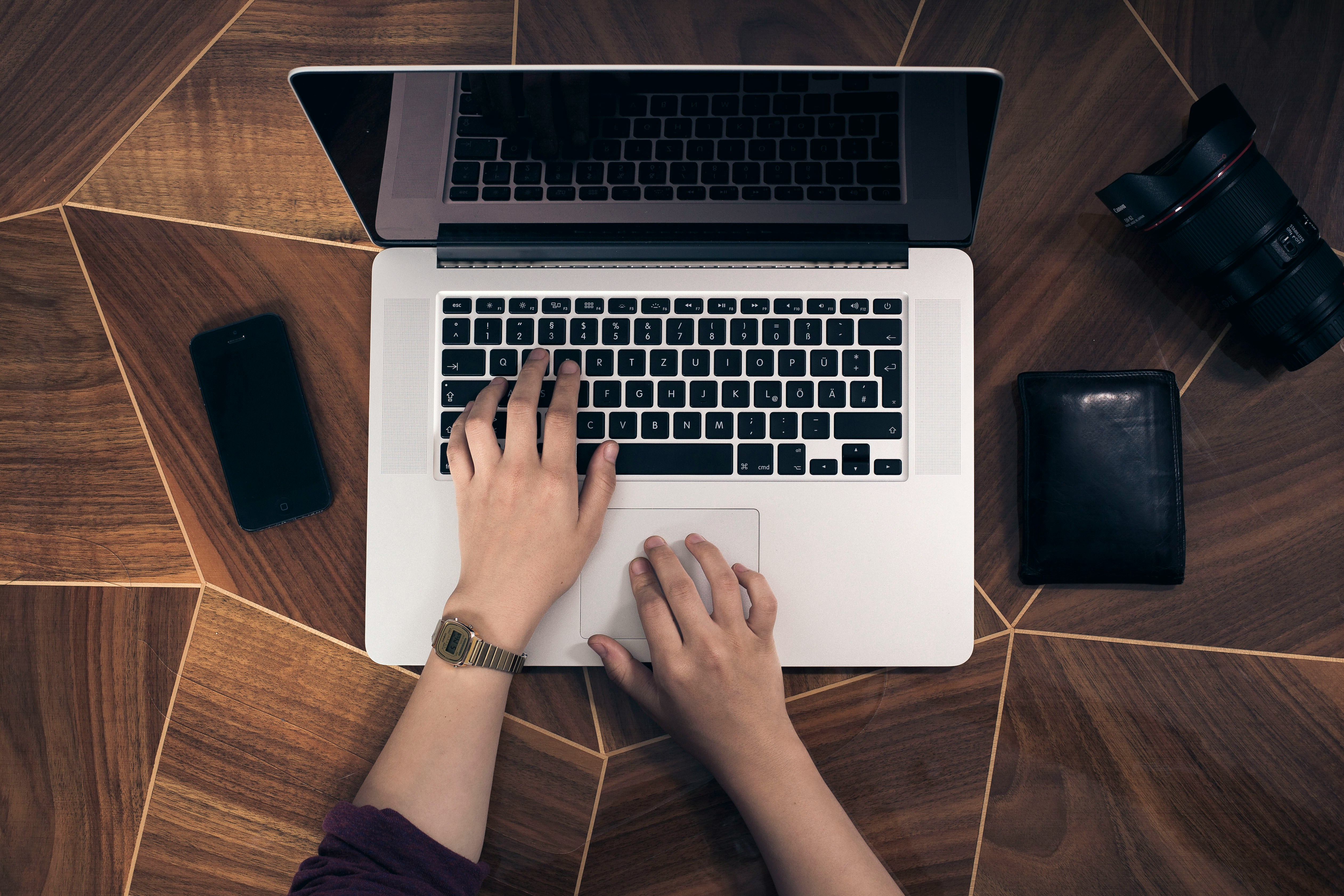 Person working on laptop at a beautiful wooden table